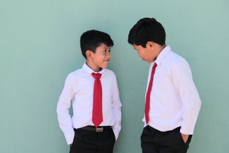 8 and 10 year old Latino children dressed in school uniforms are happy and excited about going back to schoolの写真素材