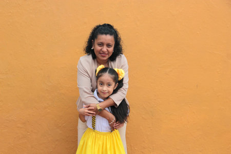Brunette single mom and 5-year-old Latina daughter show their love with hugs to celebrate Mother's Dayの写真素材