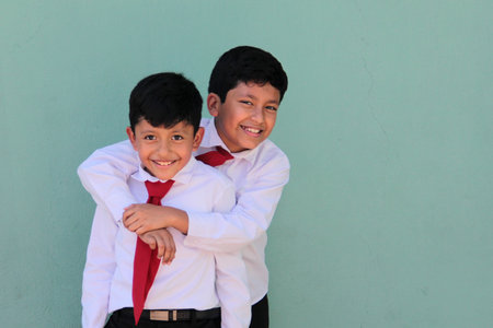 Two dark-skinned male classmates dressed in uniform are excited and happy to be back in schoolの写真素材