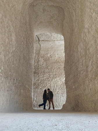 Shadows of a man and woman couple backlit in chalk mines exploring and traveling to celebrate their...