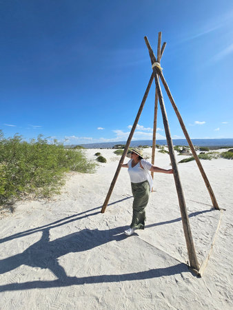 Brunette Latina adult woman walks through the gypsum dunes in the middle of the white desert enjoying the freedom and fullness of feeling natureの写真素材