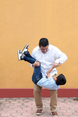 Single dad with his 8-year-old dark-skinned Latino son play and have fun together, celebrating Father's Dayの写真素材