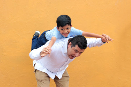 Single dad with his 8-year-old dark-skinned Latino son play and have fun together, celebrating Father's Dayの写真素材