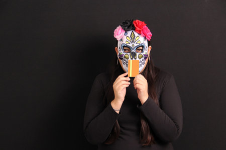 Mexican woman wearing a skeleton Catrina mask to celebrate the Day of the Dead in Mexicoの写真素材