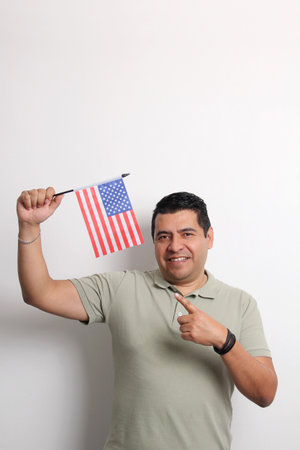 Dark-skinned Latino adult man displays the USA flag, his new nationality as a migrant