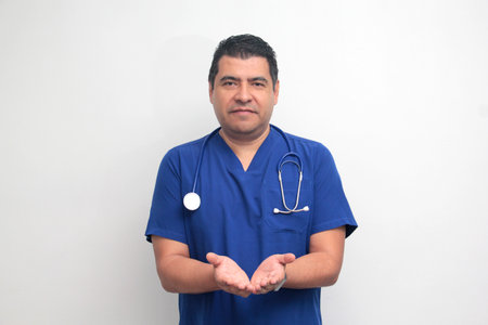 Dark-skinned male doctor specialist with a stethoscope shows pride and success in his work for the health of patientsの写真素材