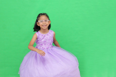 Brunette Latina girl with eyeglasses wears a princess dress, dances, points, and is surprisedの写真素材