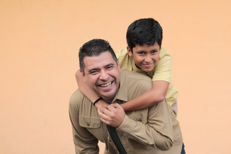 Single dad plays with his 10-year-old dark-skinned Latino son, spending time together to celebrate Father's Dayの写真素材