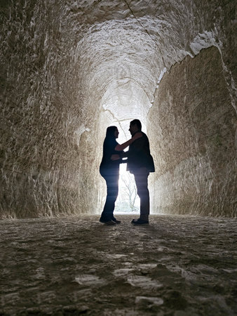 Shadows of a man and woman couple backlit in chalk mines exploring and traveling to celebrate their anniversaryの写真素材
