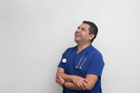 Dark-skinned Latino male doctor specialist with a stethoscope shows pride and success in his workの写真素材