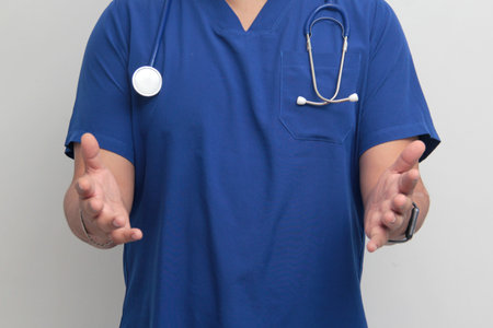 Dark-skinned Latino male doctor specialist with a stethoscope shows pride and success in his work for the health of patientsの写真素材