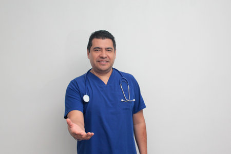 Dark-skinned Latino male doctor specialist with a stethoscope shows pride and success in his work for the health of patientsの写真素材