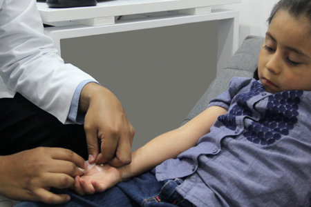Electromyography EMG and Nerve Conduction Velocity NCV of the hand and arm in a 6-year-old Latina girl with a doctorの写真素材