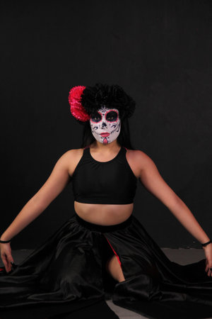 Young Mexican woman dressed up and made up with a flower crown to celebrate the Day of the Dead...