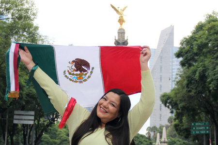 40 year old woman proudly displays the Mexican flag on the streets of Mexico to celebrate Independence Day and Cinco de Mayoの写真素材