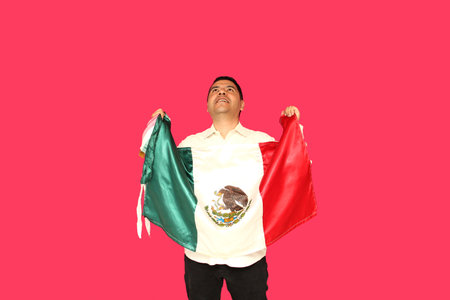 dark-skinned mexican man proudly shows the flag of Mexico in celebration of Independence Day and Cinco de Mayoの写真素材