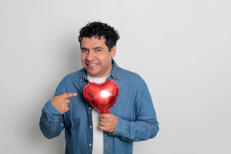 40-year-old Latino man with dark hair and curly hair celebrates Valentine's Day and shows his love...