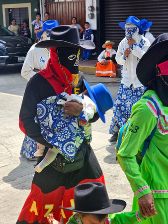 Xicotepec, Puebla, Mexico - Mar 2, 2025: Traditional Huehues dancers from the carnivals of Puebla in Mexico, dance through the streets wearing masksのeditorial素材