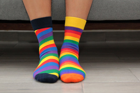 Feet with mismatched socks, different colors and designs for World Down Syndrome Day, to highlight...