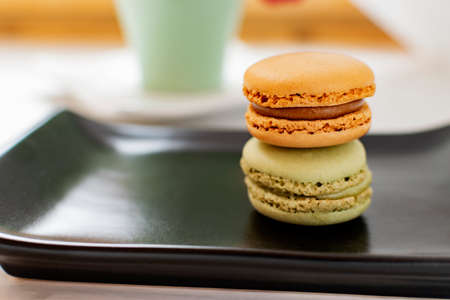 Photograph of a brown macaron and a green one.の写真素材