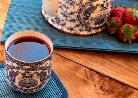 Set of teapot and chinese tea cups with strawberry tea.