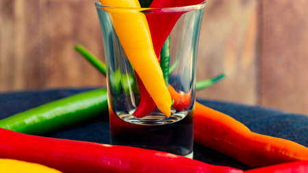 Chili peppers of red, green, orange and yellow color, copper a background of wooden boards.
