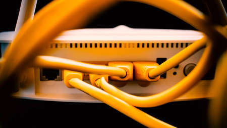 Yellow network cables connected in a white modemの写真素材