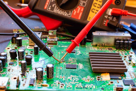 Looking at the connections of a green base plate with a testerの写真素材
