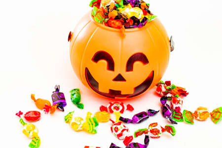 Halloween pumpkin with candies by the side, with white background.の写真素材