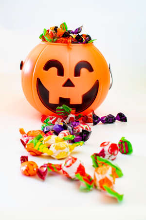 Halloween pumpkin with candies by the side, with white background.の写真素材
