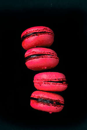 Pink macarons with cranberry flavor, on a black background.の写真素材