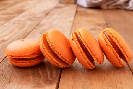 Orange macarons on a wooden table, with a vintage style.の写真素材
