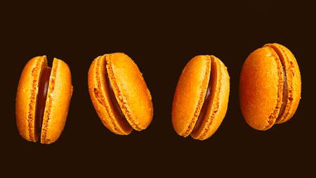 Orange oranges macarons, on a black background.の写真素材