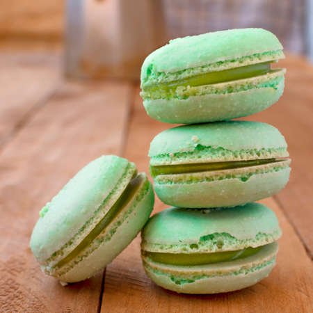 Melon macarons on a wooden table, with a vintage style.の写真素材