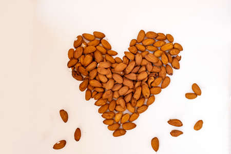 Group of almonds with a heart shape, making reference to health.の写真素材