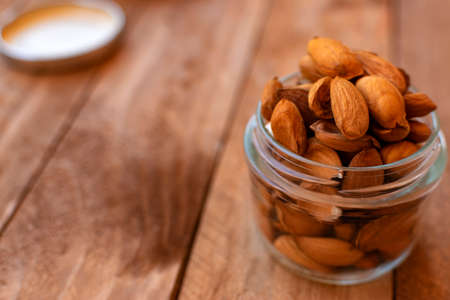 Raw almonds inside a pot, on a wooden table.の写真素材