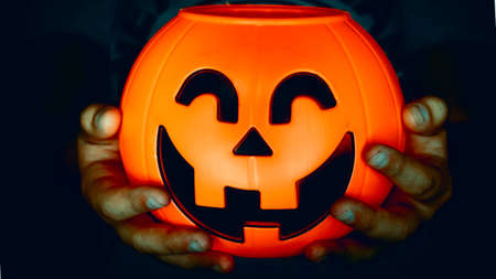 Hand holding a pumpkin of halloween baublesの写真素材
