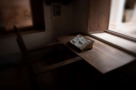 Old study table, inside a cloister of Romanesque architecture.