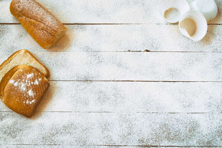 Bakery concept. Breads and pastry material on a wooden table with flour.の写真素材