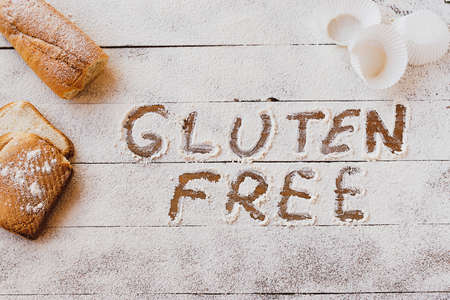 Gluten free concept. Wooden table with flour and pastry material, with the written phrase gluten free.の写真素材