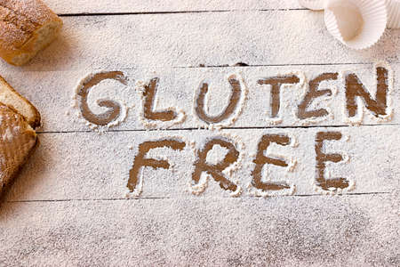 Gluten free concept. Wooden table with flour and pastry material, with the written phrase gluten free.の写真素材