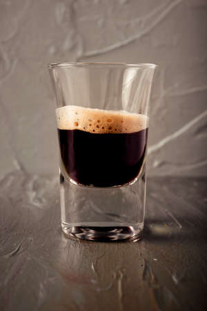 Glass of coffee with all the desaturated environment, with coffee as the main reason.