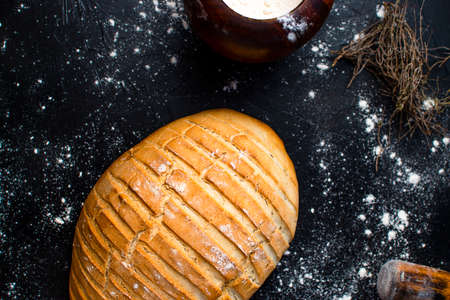 Freshly made bread with rustic style, with baker's utensils like flour, curl, cloths ...