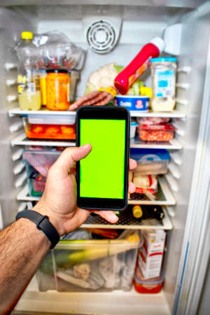 Green screen. Phone with green screen with the bottom of a refrigerator.の写真素材