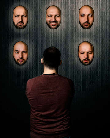 Psychology concept. A person trying to choose a mood between different expressions.の写真素材