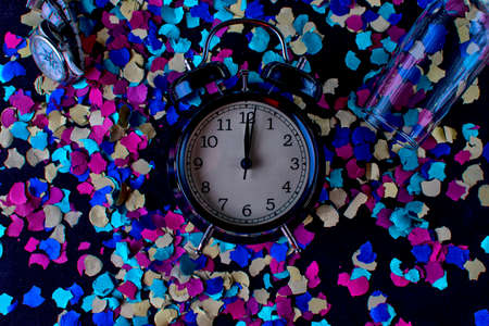 Alarm clock, clock and alarm clock with confetti in the background. End of the year concept.の写真素材