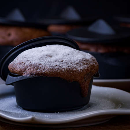 Brownie set sprinkled with sugar glass placed inside a small black casserole.の写真素材