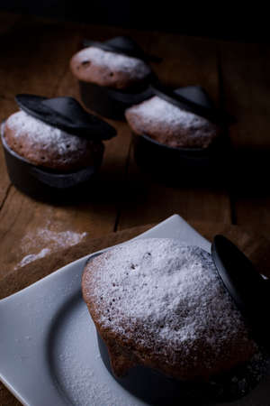 Brownie set sprinkled with sugar glass placed inside a small black casserole.