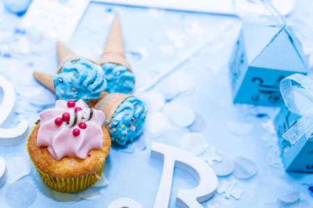 Strawberry cream cupcake on a blue table with a party background.