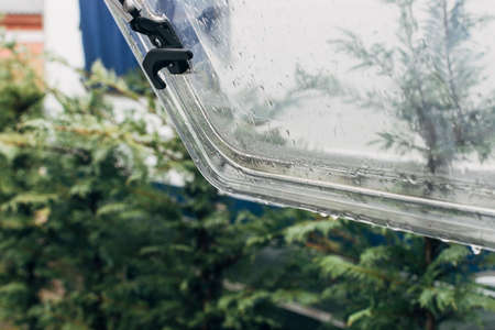 Rain falling over an open window of a caravan, watching the drops slide.の写真素材